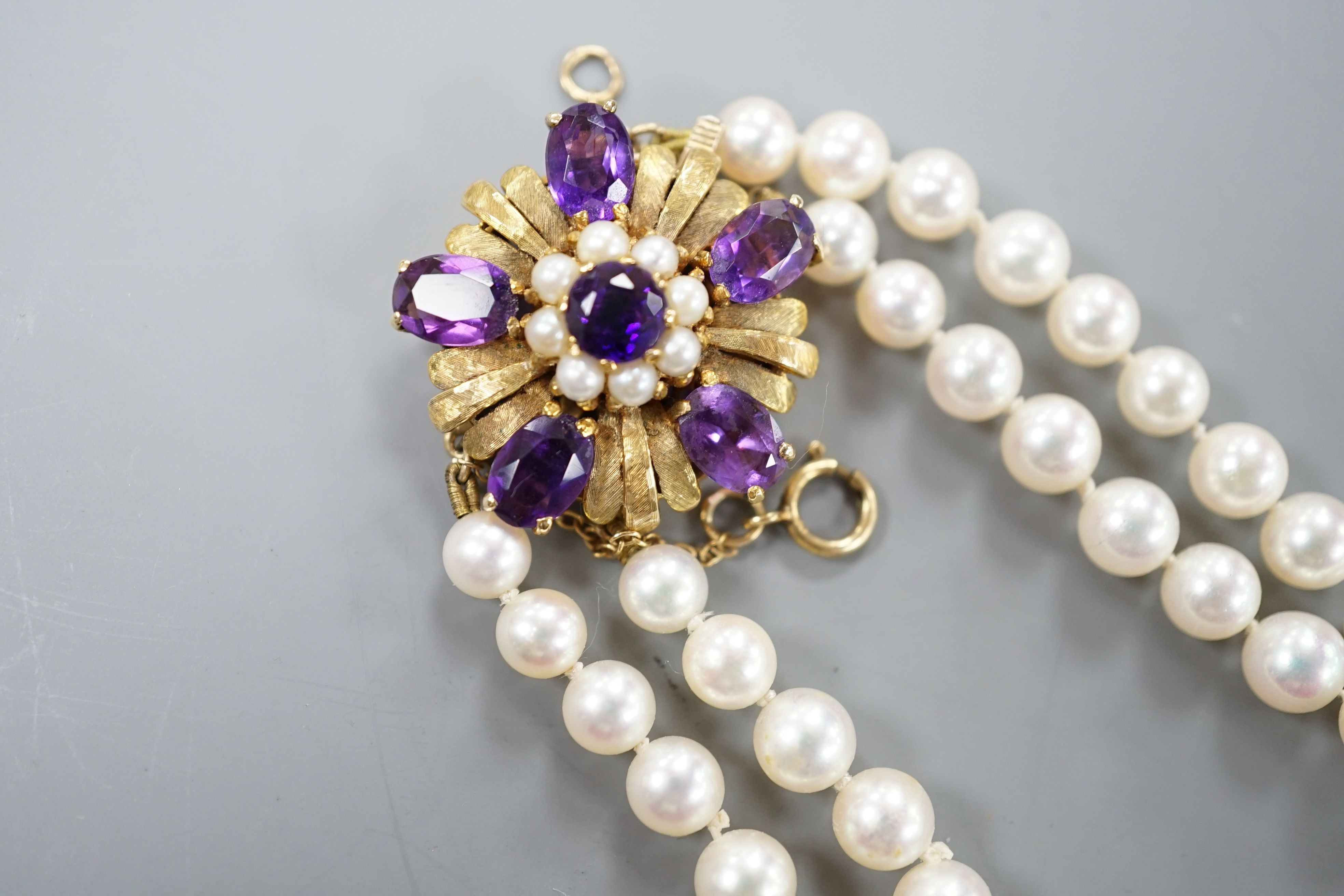 A modern double strand graduated cultured pearl necklace, with amethyst and cultured pearl cluster set 9ct clasp, 42cm.